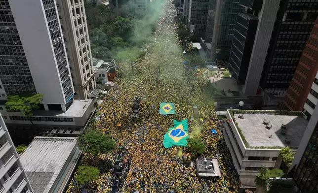 Supporters of opposition presidential candidate Sen. Flavio Bolsonaro attend his campaign rally, as they release yellow smoke flares in Sao Paulo, Brazil, Sunday, Oct. 18, 2026. (AP Photo/Andre Penner)