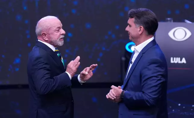 Brazilian President Luiz Inacio Lula da Silva, left, who is running for reelection, gestures as he speaks to opposition presidential candidate Sen. Flavio Bolsonaro during a televised presidential debate one week before the presidential runoff election in Sao Paulo, Brazil, Sunday, Oct. 18, 2026. (AP Photo/Andre Penner)