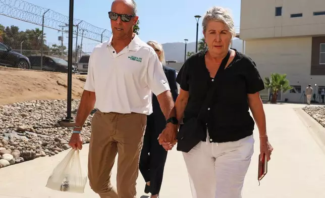 Debra and Martin Robinson, the parents of Australian brothers Callum and Jake Robinson, arrive to court for the trial of the men accused of murdering them, in Ensenada, Mexico, Thursday, Oct. 8, 2026. (AP Photo/Karen Castaneda)