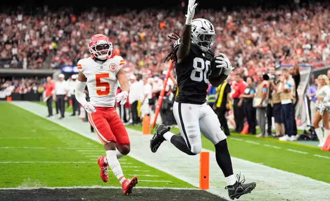 Las Vegas Raiders tight end Ian Thomas (80) scores a touchdown past Kansas City Chiefs cornerback Mansoor Delane (5) during the first half of an NFL football game in Las Vegas, Sunday, Oct. 4, 2026. (AP Photo/John Locher)