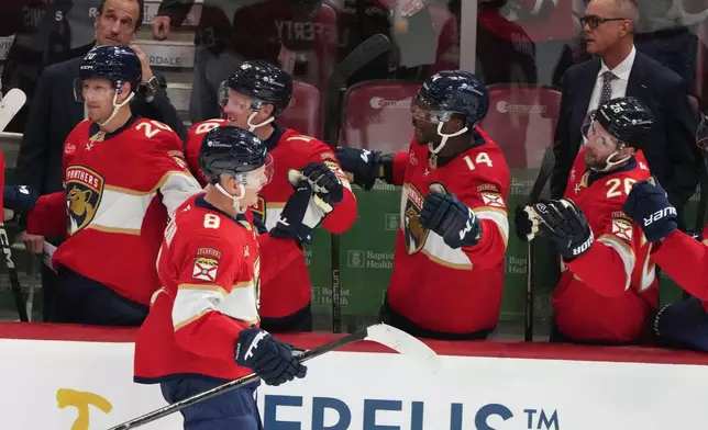 Florida Panthers left wing Brady Tkachuk (8) is congratulated after scoring a goal during the third period of an NHL hockey game against the Vancouver Canucks, Thursday, Oct. 15, 2026, in Sunrise, Fla. (AP Photo/Lynne Sladky)