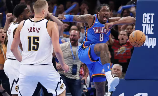 Oklahoma City Thunder guard Jalen Williams (8) reacts after dunking the ball near Denver Nuggets center Nikola Jokic (15) and forward Alpha Diallo, left, during the second half of an NBA basketball game Thursday, Oct. 22, 2026, in Oklahoma City. (AP Photo/Nate Billings)