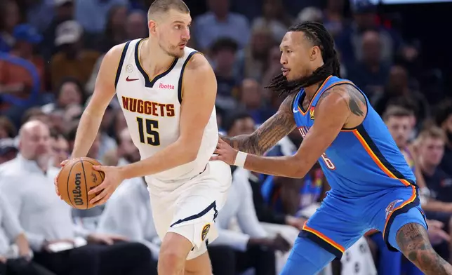 Denver Nuggets center Nikola Jokic (15) holds the ball as Oklahoma City Thunder forward Jaylin Williams, right, defends during the first half of an NBA basketball game Thursday, Oct. 22, 2026, in Oklahoma City. (AP Photo/Nate Billings)