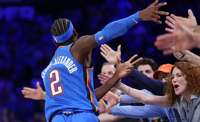 Oklahoma City Thunder guard Shai Gilgeous-Alexander celebrates with fans after making a basket during the second half of an NBA basketball game against the Denver Nuggets, Thursday, Oct. 22, 2026, in Oklahoma City. (AP Photo/Nate Billings)