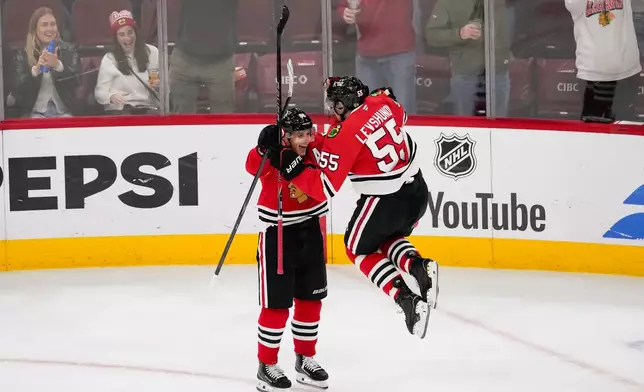 Chicago Blackhawks right wing Patrick Kane, left, celebrates after the winning goal by defenseman Artyom Levshunov (55) during overtime of an NHL hockey game against the Winnipeg Jets, Thursday, Oct. 15, 2026, in Chicago. (AP Photo/Harry Figiel)