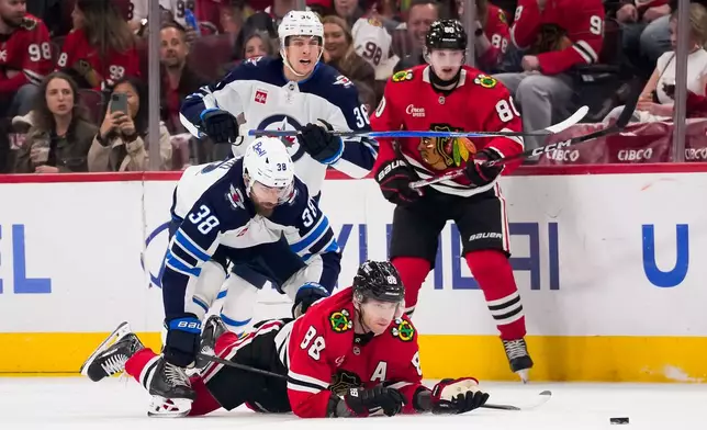 Chicago Blackhawks right wing Patrick Kane (88) looks at the puck after being checked by Winnipeg Jets defenseman Mario Ferraro (38) during the first period of an NHL hockey game, Thursday, Oct. 15, 2026, in Chicago. (AP Photo/Harry Figiel)