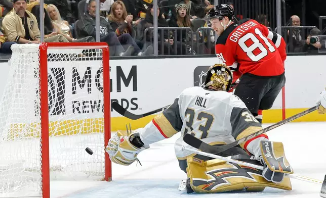 New Jersey Devils right wing Arseny Gritsyuk (81) scores against Vegas Golden Knights goaltender Adin Hill (33) during the second period of an NHL hockey game Friday, Oct. 30, 2026, in Las Vegas. (Steve Marcus/Las Vegas Sun via AP)