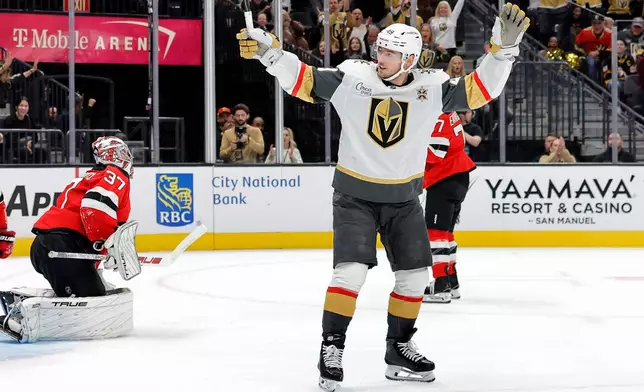 Vegas Golden Knights left wing Ivan Barbashev (49) celebrates after scoring past New Jersey Devils goaltender Connor Hellebuyck (37) during the first period of an NHL hockey game Friday, Oct. 30, 2026, in Las Vegas. (Steve Marcus/Las Vegas Sun via AP)
