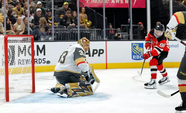 New Jersey Devils center Jack Hughes (86) scores past Vegas Golden Knights goaltender Adin Hill (33) during the second period of an NHL hockey game Friday, Oct. 30, 2026, in Las Vegas. (Steve Marcus/Las Vegas Sun via AP)