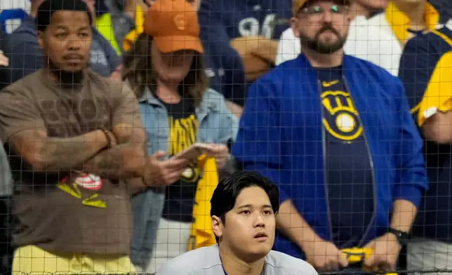 Los Angeles Dodgers designated hitter Shohei Ohtani watches from the dugout during the ninth inning of Game 1 of baseball's National League Championship Series between the Milwaukee Brewers and the Los Angeles Dodgers, Sunday, Oct. 11, 2026, in Milwaukee. (AP Photo/Ashley Landis)