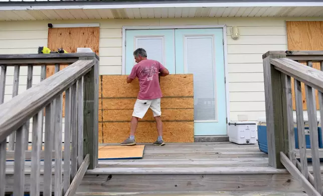 Larry Smith boards up his home with plywood ahead of Hurricane Isaias' expected landfall along the Gulf Coast in Dauphin Island, Alabama, Thursday, Oct. 8, 2026. (AP Photo/Octavio Jones)
