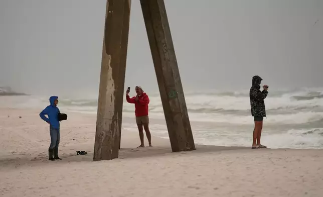People film the surf as Hurricane Isaias approaches Pensacola Beach, Fla., Friday, Oct. 9, 2026. (AP Photo/Gerald Herbert)