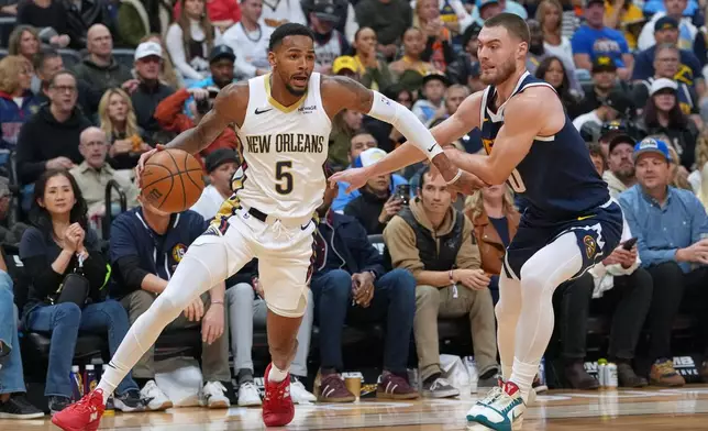 New Orleans Pelicans guard Dejounte Murray, left, drives past Denver Nuggets guard Christian Braun in the first half of an NBA basketball game Saturday, Oct. 24, 2026, in Denver. (AP Photo/David Zalubowski)