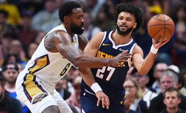 Denver Nuggets guard Jamal Murray, right, passes the ball as New Orleans Pelicans center DeAndre Jordan defends in the first half of an NBA basketball game Saturday, Oct. 24, 2026, in Denver. (AP Photo/David Zalubowski)
