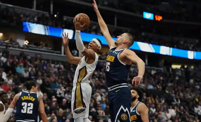 New Orleans Pelicans guard Jeremiah Fears, left, drives to the rim past Denver Nuggets center Nikola Jokić in the first half of an NBA basketball game Saturday, Oct. 24, 2026, in Denver. (AP Photo/David Zalubowski)
