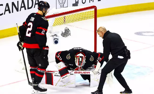 Ottawa Senators head athletic therapist Domenic Nicoletta, right, attends to goaltender Linus Ullmark (35) during third period of an NHL hockey game against the Florida Panthers in Ottawa, on Wednesday, Oct. 21, 2026. (Keito Newman/The Canadian Press via AP)
