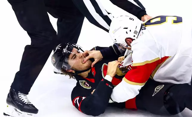 Florida Panthers Sam Bennett (9) reaches his hand into the face of Ottawa Senators Ridly Greig (71) in a fight during third period of an NHL hockey game in Ottawa, on Wednesday, Oct. 21, 2026. (Keito Newman/The Canadian Press via AP)