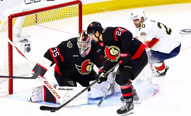 Ottawa Senators' Dylan Cozens (24) looks to clear the puck from in front of Ottawa Senators goaltender Linus Ullmark (35) as Florida Panthers' Lars Eller (20) looks for the rebound during third period of an NHL hockey game in Ottawa, on Wednesday, Oct. 21, 2026. (Keito Newman/The Canadian Press via AP)