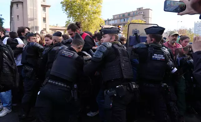 Riot police face high school students as they gather before a demonstration against under-resourced schools in Paris, Tuesday, Oct. 6, 2026. (AP Photo/Aurelien Morissard)