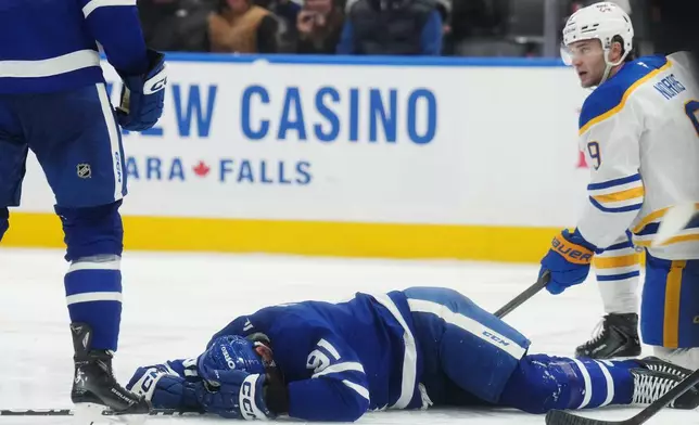 Toronto Maple Leafs' John Tavares, bottom, lies on the ice after an injury during the third period of an NHL hockey game against the Buffalo Sabres in Toronto, Thursday, Oct. 15, 2026. (Nathan Denette/The Canadian Press via AP)