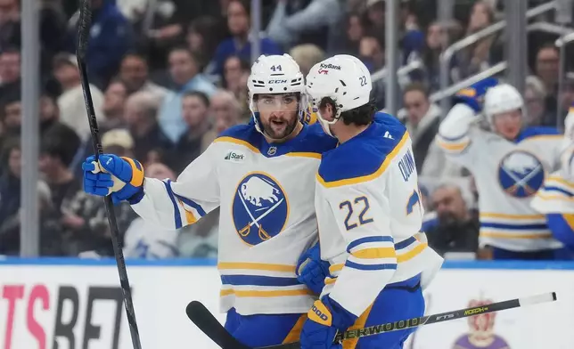 Buffalo Sabres' Dennis Gilbert (44) celebrates with Jack Quinn (22) after scoring against the Toronto Maple Leafs during the third period of an NHL hockey game in Toronto, Thursday, Oct. 15, 2026. (Nathan Denette/The Canadian Press via AP)