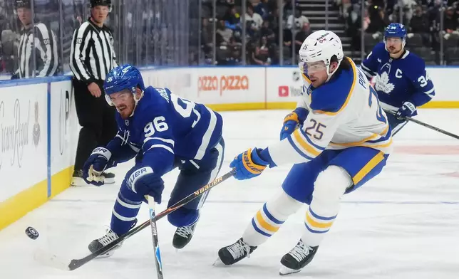 Toronto Maple Leafs' Jack Roslovic (96) and Buffalo Sabres' Owen Power (25) battle for the puck during the second period of an NHL hockey game in Toronto, Thursday, Oct. 15, 2026. (Nathan Denette/The Canadian Press via AP)