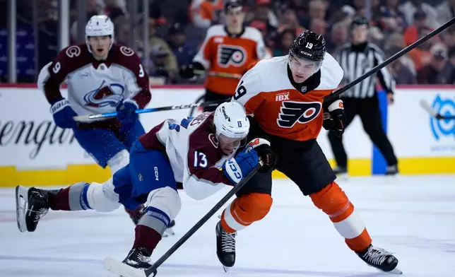 Colorado Avalanche's T.J. Hughes (13) collides with Philadelphia Flyers' Hunter McDonald (19) during the first period of an NHL hockey game Monday, Oct. 19, 2026, in Philadelphia. (AP Photo/Matt Slocum)