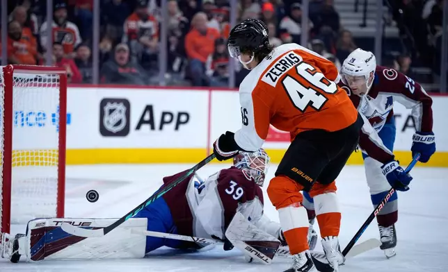 Philadelphia Flyers' Trevor Zegras (46) cannot get a shot past Colorado Avalanche's Mackenzie Blackwood (39) and Nathan MacKinnon (29) during the second period of an NHL hockey game Monday, Oct. 19, 2026, in Philadelphia. (AP Photo/Matt Slocum)