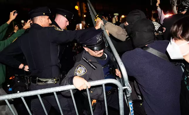 New York City police try to block protestors near the scene of a shooting on Thursday, Oct. 8, 2026, in New York. (AP Photo/Seth Wenig)