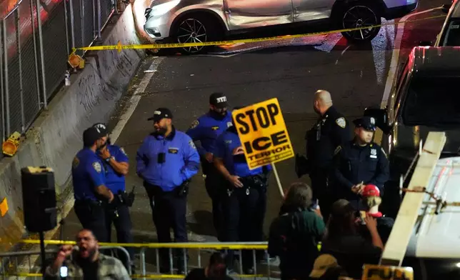 People gather at the scene of a shooting as law enforcement work the area Thursday, Oct. 8, 2026, in New York. (AP Photo/Seth Wenig)