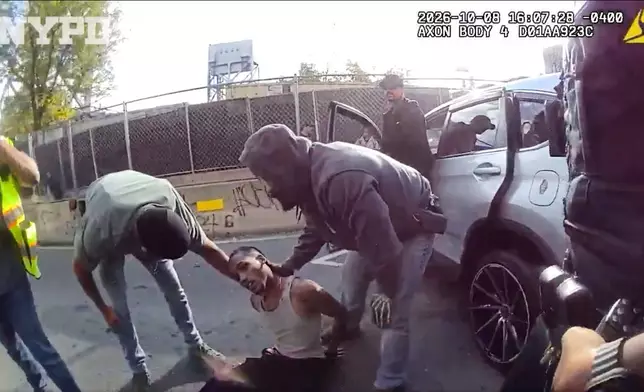 In this image taken from police-worn body camera video released the New York City Police Department (NYPD), law enforcement personnel tend to a Oscar Belgal, 28, a Dominican man who was shot by Federal immigration officers, Thursday, Oct. 8, 2026, in New York, as he drove his car with a 5-year-old boy inside. (NYPD via AP)