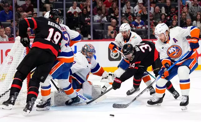 New York Islanders' Ryan Pulock (6) clears the puck as Ottawa Senators' Stephen Halliday (34) looks for a chance against Islanders goaltender Semyon Varlamov, third from left, during the second period of an NHL hockey game in Ottawa, Ontario, Thursday, Oct. 15, 2026. (Justin Tang/The Canadian Press via AP)