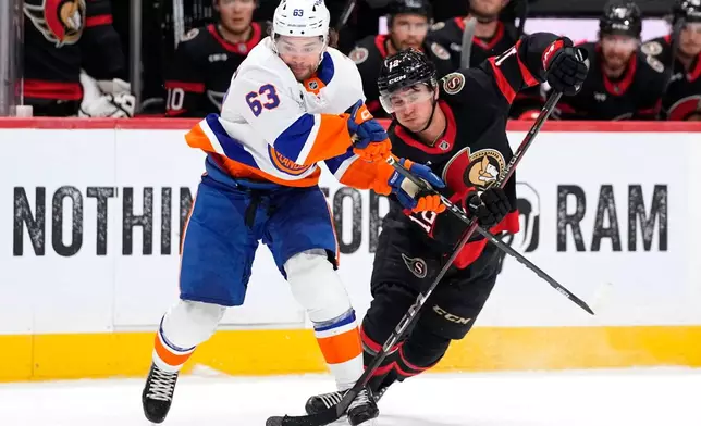 New York Islanders' Matias MacCelli (63) takes the puck from Ottawa Senators' Shane Pinto (12) during the first period of an NHL hockey game in Ottawa, Thursday, Oct. 15, 2026. (Justin Tang/The Canadian Press via AP)
