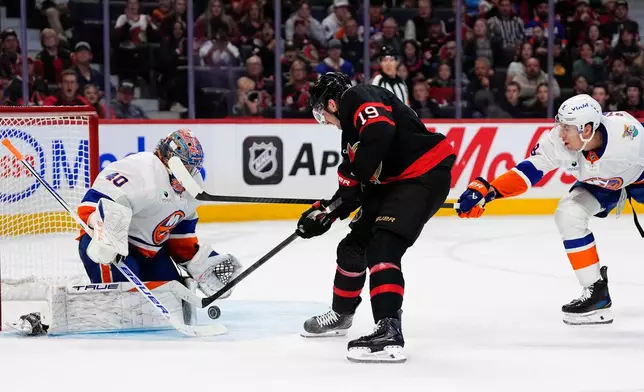 New York Islanders goaltender Semyon Varlamov (40) makes a save against Ottawa Senators' Drake Batherson (19) as Islanders' Logan Stanley (8) defends during the second period of an NHL hockey game in Ottawa, Ontario, Thursday, Oct. 15, 2026. (Justin Tang/The Canadian Press via AP)