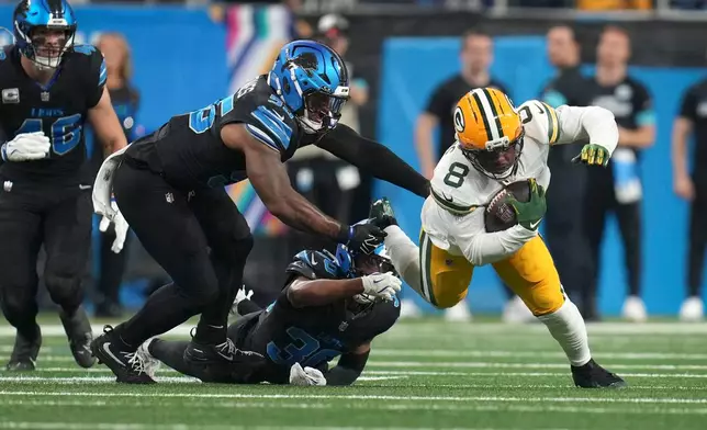 Green Bay Packers running back Josh Jacobs (8) is tackled by Detroit Lions linebacker Derrick Barnes, left, during the first half of an NFL football game, Sunday, Oct. 25, 2026, in Detroit. (AP Photo/Paul Sancya)