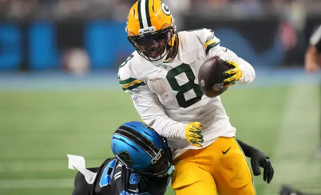 Green Bay Packers running back Josh Jacobs (8) breaks a tackle by Detroit Lions cornerback Keith Abney II (6) during a touchdown reception in the second half of an NFL football game, Sunday, Oct. 25, 2026, in Detroit. (AP Photo/Paul Sancya)