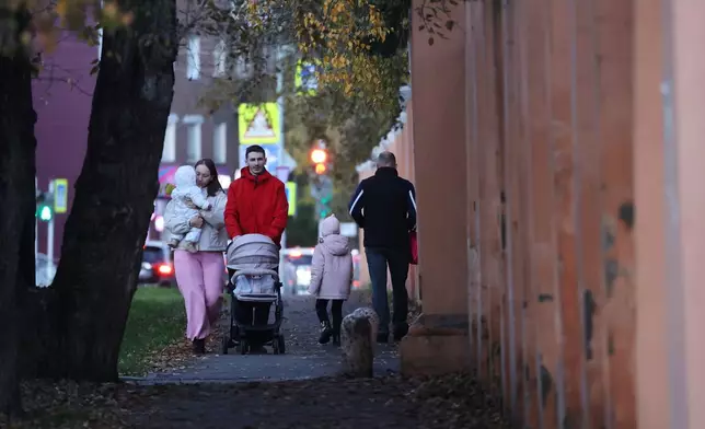 People walk past the fence of the building of the Irkutsk Anti-Plague Research Institute of Siberia and the Far East in Irkutsk, Russi, on Wednesday, Oct. 7, 2026. (AP Photo)