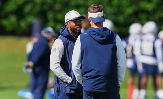 Christian Parker, left, the Dallas Cowboys defensive coordinator, talks with head coach Brian Schottenheimer, right, during practice at the NFL football team's headquarters, Friday, Oct. 16, 2026, in Frisco, Texas. (AP Photo/Tony Gutierrez)