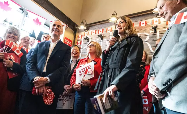 Canada's Prime Minister Mark Carney attends a national unity rally in Red Deer, Alberta, alongside, from left, Monte Solberg, Alberta Premier Danielle Smith, and former Premier Ed Stelmach, Friday, Oct. 16, 2026. (John Ulan/The Canadian Press via AP)