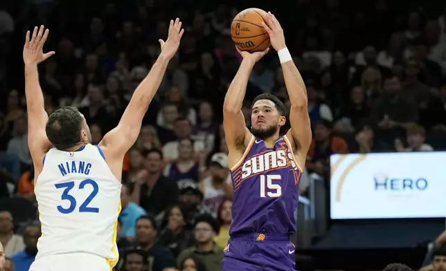 Phoenix Suns guard Devin Booker (15) shoots a 3-pointer over Golden State Warriors forward Georges Niang (32) during an NBA basketball game, Saturday, Oct. 24, 2026, in Phoenix. (AP Photo/Ross D. Franklin)