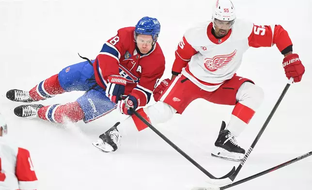 Montreal Canadiens' Mike Matheson (8) and Detroit Red Wings' Keegan Kolesar (55) vie for the puck during first period of an NHL hockey game in Montreal on Saturday, Oct. 10, 2026. (Graham Hughes/The Canadian Press via AP)
