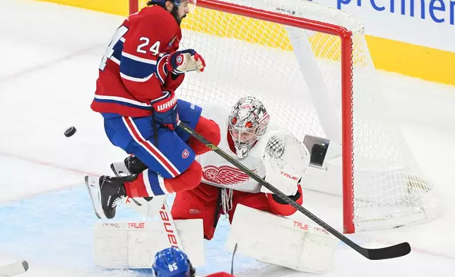 Montreal Canadiens' Phillip Danault (24) leaps over a shot by teammate Alexandre Texier (85) on Detroit Red Wings goaltender Daniil Tarasov (80) during second period of an NHL hockey game in Montreal on Saturday, Oct. 10, 2026. (Graham Hughes/The Canadian Press via AP)