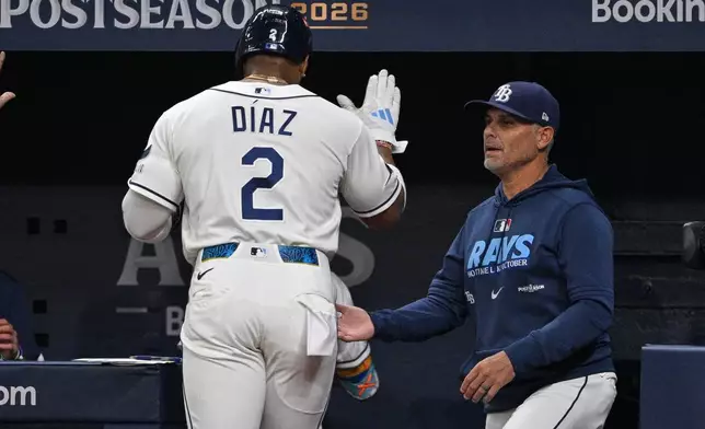 Tampa Bay Rays' Yandy Díaz (2) is congratulated by manager Kevin Cash after scoring during the first inning in Game 2 of an American League Division Series baseball game against the New York Yankees Monday, Oct. 5, 2026, in St. Petersburg, Fla. (AP Photo/Phelan Ebenhack)