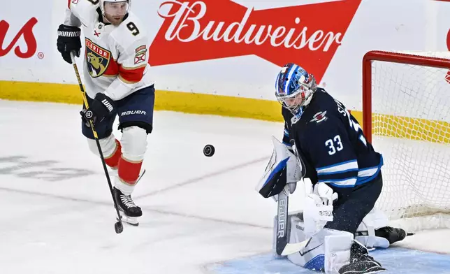 Winnipeg Jets goaltender Clay Stevenson (33) makes a save on Florida Panthers' Sam Bennett (9) during third period NHL action in Winnipeg on Tuesday, Oct. 27, 2026. (Fred Greenslade/The Canadian Press via AP)