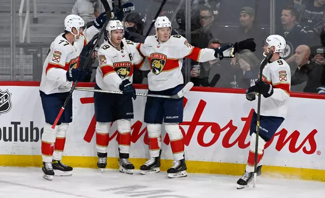 Florida Panthers' Brady Tkachuk (8) celebrates his goal on the Winnipeg Jets with Niko Mikkola (77), Matthew Tkachuk (19) and Sam Bennett (9) during third period NHL action in Winnipeg on Tuesday, Oct. 27, 2026. (Fred Greenslade/The Canadian Press via AP)