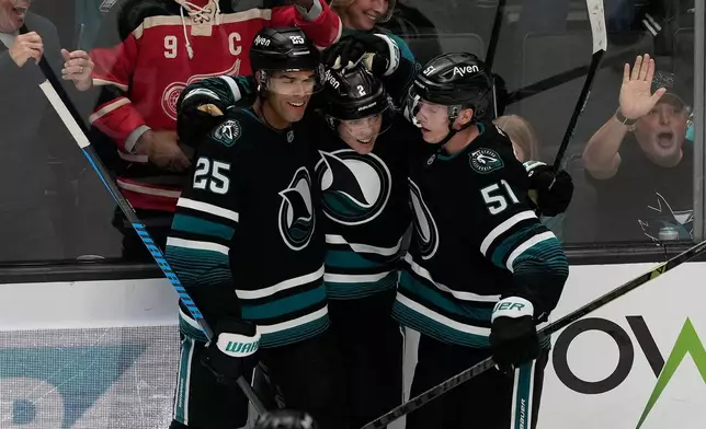 San Jose Sharks center Will Smith, middle, is congratulated by defenseman Darnell Nurse (25) and right wing Collin Graf (51) after scoring against the Vancouver Canucks during the third period of an NHL hockey game, Thursday, Oct. 29, 2026, in San Jose, Calif. (AP Photo/Jeff Chiu)