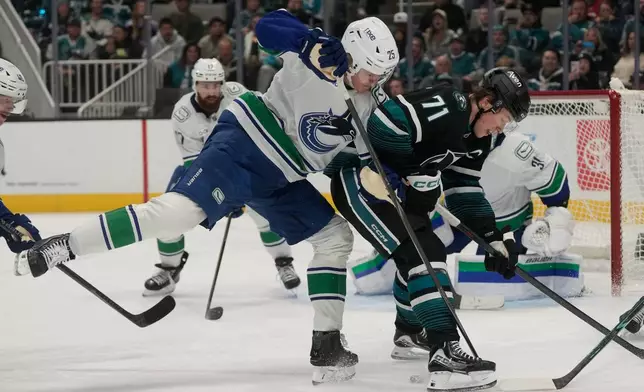 San Jose Sharks center Macklin Celebrini (71) looks for the puck against Vancouver Canucks defenseman Elias Pettersson (25) during the first period of an NHL hockey game, Thursday, Oct. 29, 2026, in San Jose, Calif. (AP Photo/Jeff Chiu)