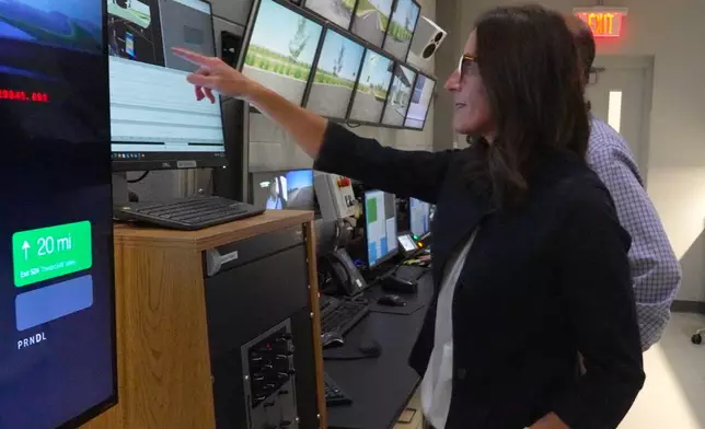 In this image from video, Maureen August, General Motors Research Development senior manager, discusses a driving simulation with a colleague inside a control room at the automaker's Global Technical Center Friday, Sept. 18, 2026, in Warren, Mich. (AP Photo/Mike Householder)
