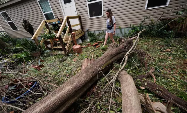 Baleigh Ziglar walks around downed trees in front of her mother's home in the aftermath of Hurricane Isaias in Milton, Fla., Saturday, Oct. 10, 2026. (AP Photo/Gerald Herbert)