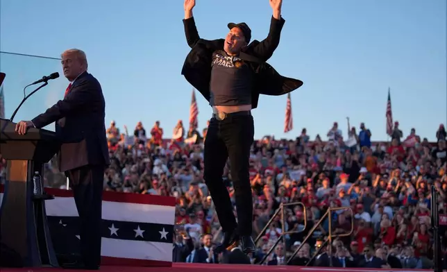 FILE - Elon Musk jumps on the stage as Republican presidential nominee former President Donald Trump speaks at a campaign rally at the Butler Farm Show in Butler, Pa., on Oct. 5, 2024. (AP Photo/Evan Vucci, File)